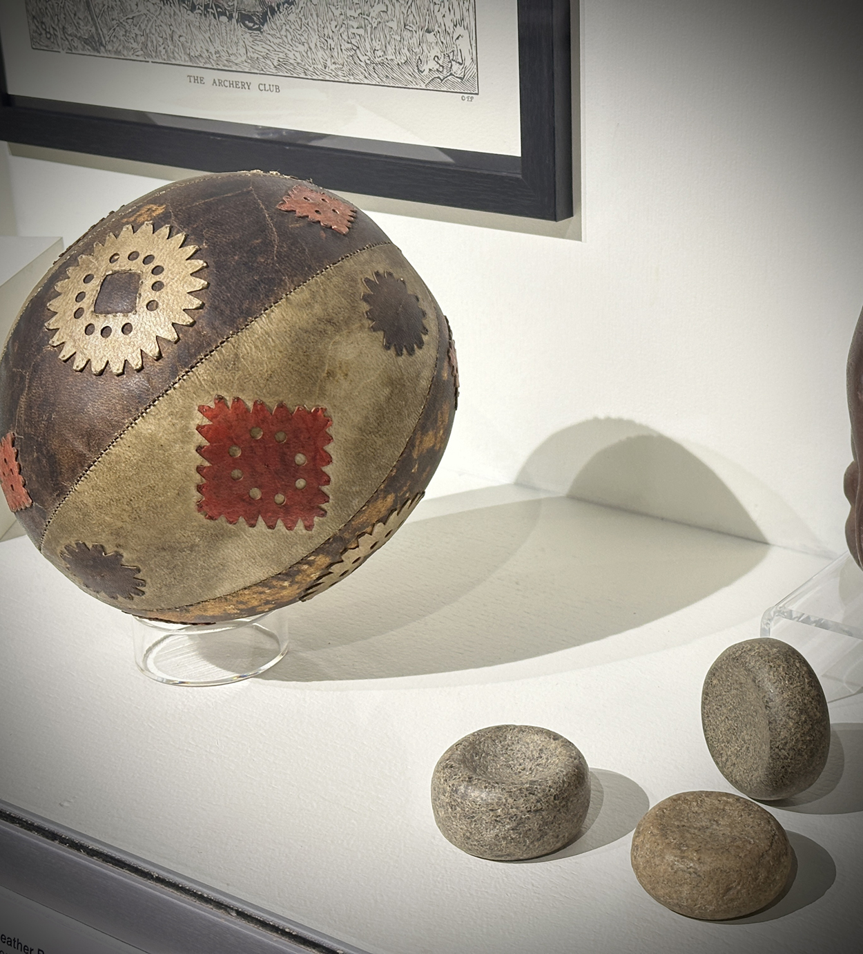 A leather ball and round game pieces made of stone.