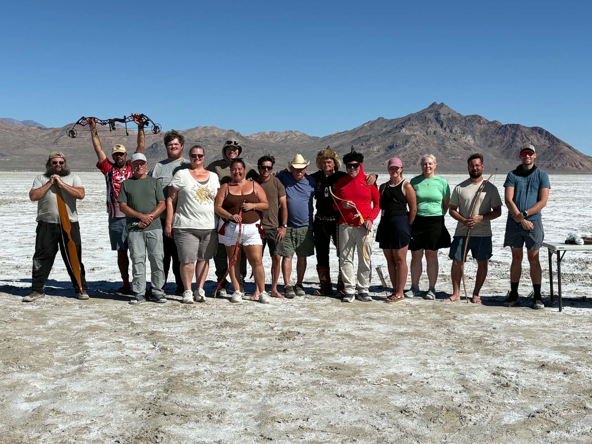 A group of archers stands on a salt flat in Utah.